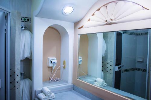 a bathroom with a shower and a mirror at Hotel Sands Arenas in Mazatlán