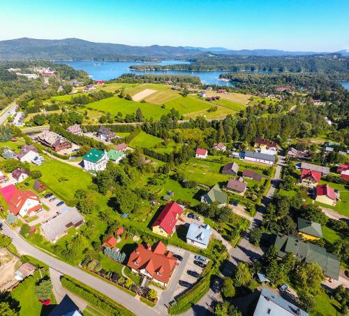 an aerial view of a town with houses and a lake at Dworek Julia Komfortowe Pokoje z Klimatyzacją nad Soliną in Polańczyk