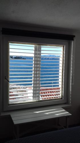a window with a view of the ocean through it at Studio with magic view in Podgora