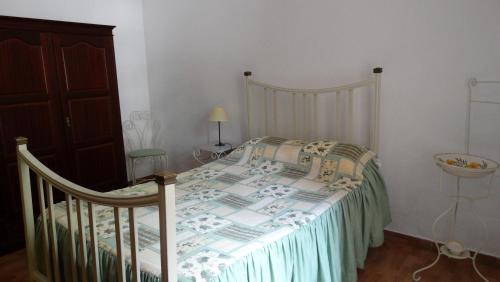 a bedroom with a bed with a bedspread at Casa de Férias in Monchique