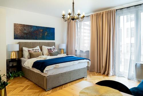 a bedroom with a large bed and a chandelier at Apartament Oławska in Wrocław
