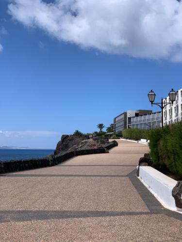 a road next to the ocean with buildings and the sky at Villa Brisa del Mar in Playa Blanca