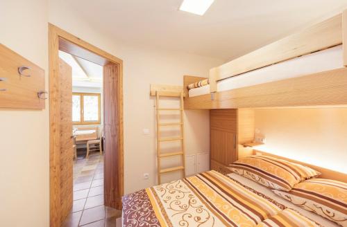 a bedroom with two bunk beds and a dining room at Apartment Jezerca - Krvavec in Cerklje na Gorenjskem