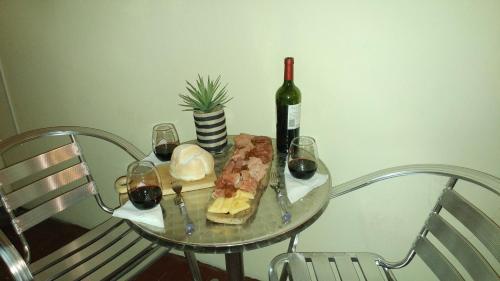 a glass table with a bottle of wine and a sandwich at San Martin 900 con estacionamiento in Cipolletti