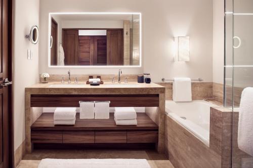 a bathroom with a sink and a tub and a mirror at Four Seasons Resort Punta Mita in Punta Mita