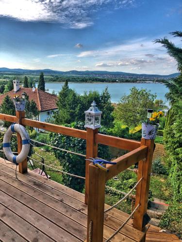 a wooden deck with a view of a lake at Villa Borostyán in Tihany