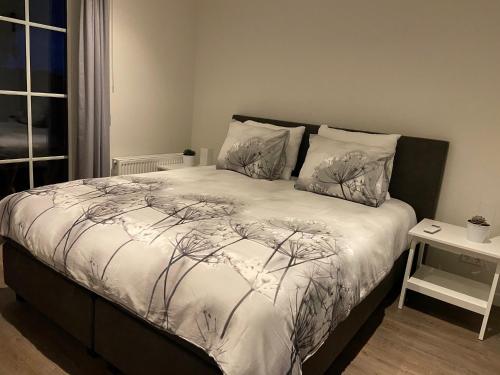 una camera da letto con un letto e un piumone bianco di Hof van Lenthe appartement De Mars a Dalfsen