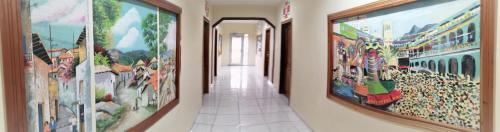 a hallway with many paintings on the walls at Hotel Carnaval in La Ceiba