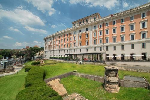 a large building with a clock on the side of it at NH Collection Palazzo Cinquecento in Rome