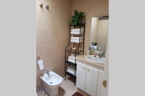a bathroom with a white toilet and a sink at Residencial Cary II - Apartamento Familiar in Poris de Abona