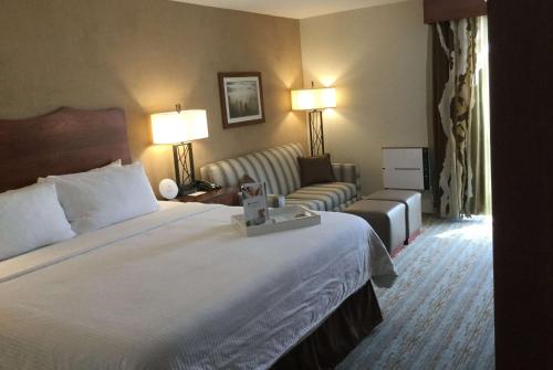 a hotel room with a bed and a couch at Wyndham Visalia in Visalia