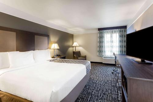 a hotel room with a large bed and a flat screen tv at La Quinta by Wyndham Seguin in Seguin