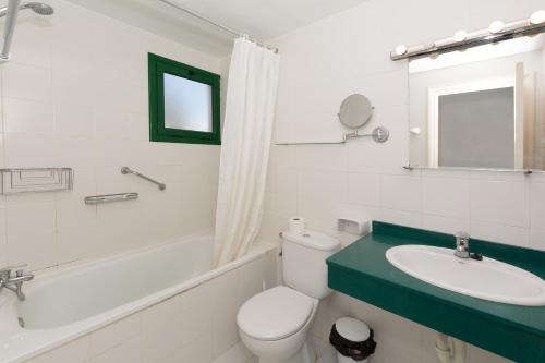 a bathroom with a sink and a toilet and a bath tub at Conylanza Los Cármenes in Costa Teguise