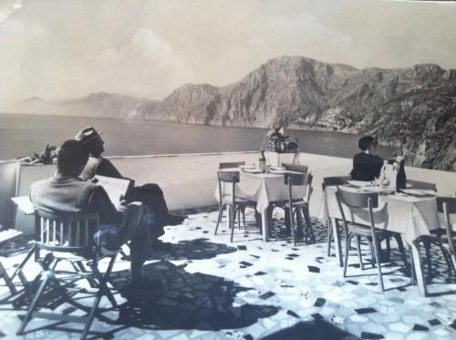 a black and white photo of people sitting at tables at Tramonto d'Oro in Praiano