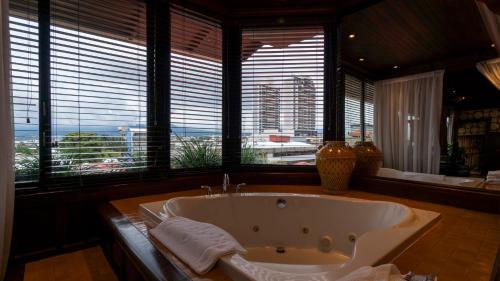 y baño con bañera grande y ventanas. en Grano de Oro Hotel, en San José