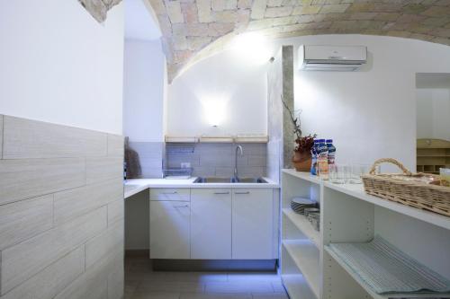 eine Küche mit weißen Schränken und einem Waschbecken in der Unterkunft Guesthouse Sant'Angelo in Rom