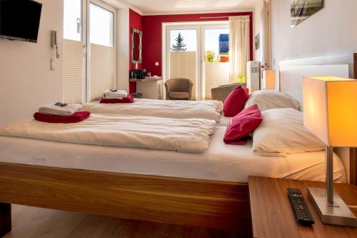 a bedroom with two beds with red walls at Seaside-Strandhotel in Timmendorfer Strand