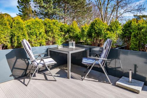 a patio with a table and two chairs on a deck at Seaside-Strandhotel in Timmendorfer Strand