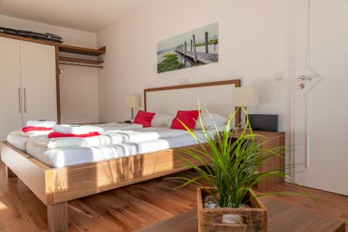 a bedroom with a large bed with red pillows at Seaside-Strandhotel in Timmendorfer Strand