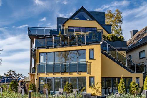a yellow house with a deck and a balcony at Seaside-Strandhotel in Timmendorfer Strand