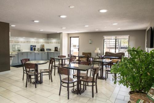 un ristorante con tavoli e sedie e una cucina di Mockingbird Inn & Suites a Monroeville