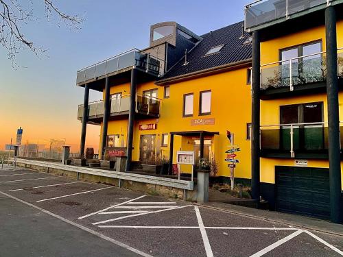 a yellow building with a parking lot in front of it at Seaside-Strandhotel in Timmendorfer Strand