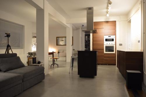 a living room with a couch and a kitchen at LOFT bed & breakfast in A Coruña