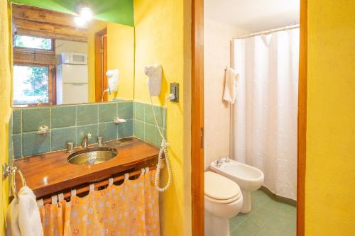y baño con lavabo, aseo y ducha. en Grenouille en Villa General Belgrano