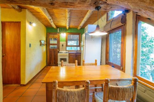 a dining room with a wooden table and chairs at Grenouille in Villa General Belgrano