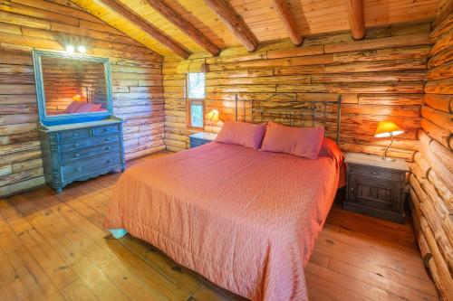 a bedroom with a bed in a log cabin at Grenouille in Villa General Belgrano