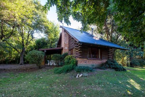 a small log cabin with a blue roof at Grenouille in Villa General Belgrano