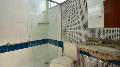 W łazience znajduje się umywalka, toaleta i lustro. w obiekcie Triflat Minas Praia w mieście Cabo Frio