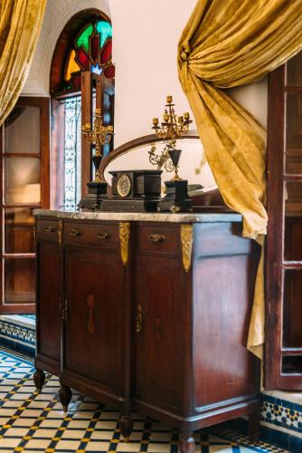 a wooden dresser in a room with a window at La Maison Bleue Batha in Fez