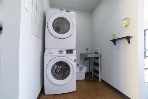 a washer and dryer in a white laundry room at Hotel Círculo Condesa in Mexico City
