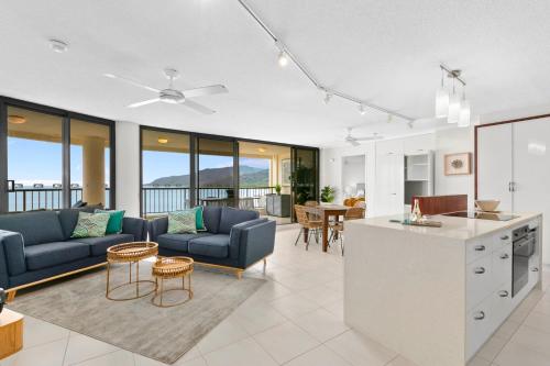 eine Küche und ein Wohnzimmer mit einem Sofa und einem Tisch in der Unterkunft Cairns Aquarius in Cairns