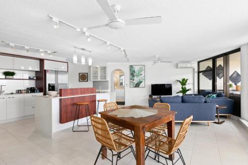 a kitchen and living room with a table and chairs at Cairns Aquarius in Cairns