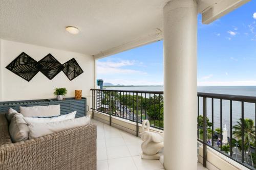 a balcony with a couch and a view of the ocean at Cairns Aquarius in Cairns
