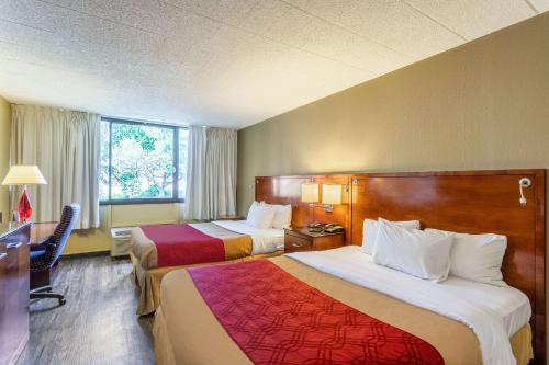 a hotel room with two beds and a desk at Econo Lodge in Fredonia