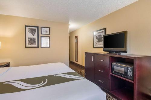 a hotel room with a bed and a flat screen tv at Quality Inn in Sweetwater