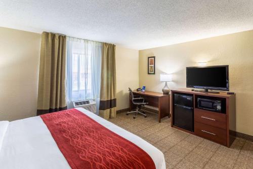 a hotel room with a bed and a flat screen tv at Comfort Inn in Waukesha
