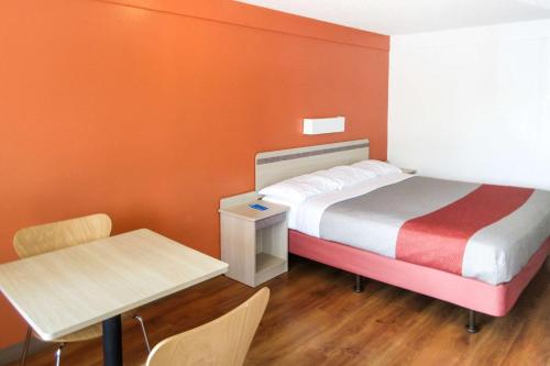 a small room with a bed and a table at Rodeway Inn Altoona Orchard Plaza in Altoona