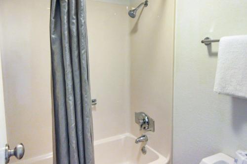 a shower in a bathroom with a shower curtain at Rodeway Inn Altoona Orchard Plaza in Altoona