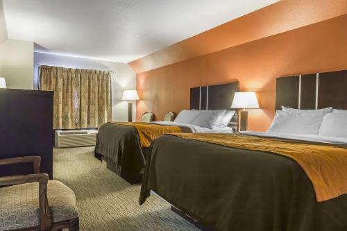 Comfort Inn & Suites في يوركتون: غرفة فندق بسريرين بجدران برتقالية