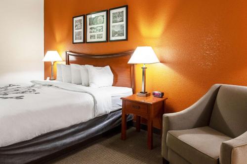 a hotel room with a bed and a chair at Sleep Inn & Suites in Hobbs