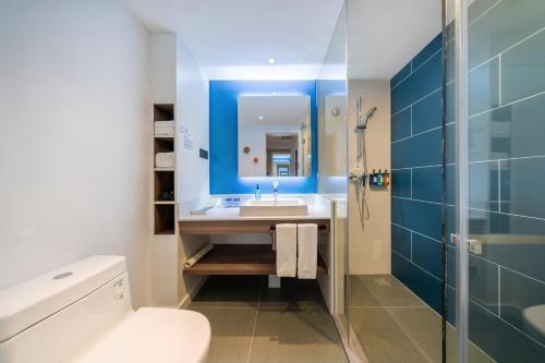 a bathroom with a sink and a toilet and a mirror at Holiday Inn Express Hangzhou Westlake East, an IHG Hotel in Hangzhou