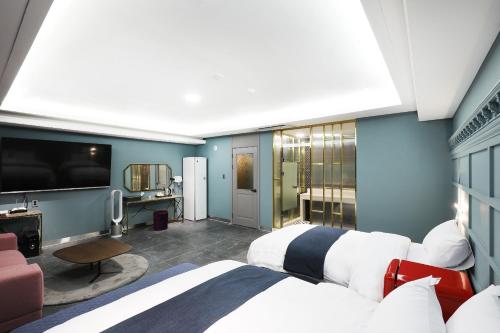 1 Schlafzimmer mit 2 Betten und einem Flachbild-TV in der Unterkunft El Tower Hotel in Gunsan