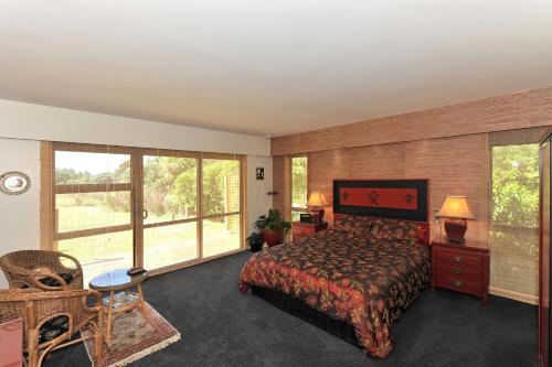 a bedroom with a bed and large windows at Twin Waters Lodge in Collingwood