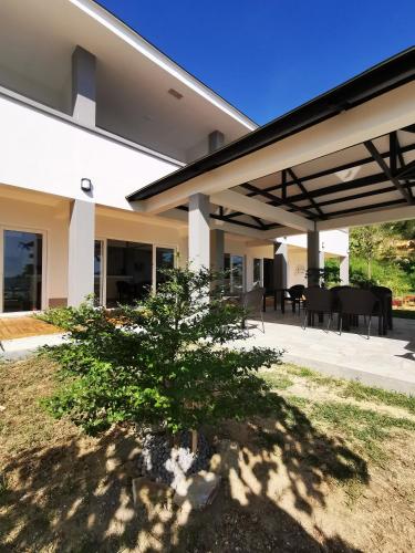 a house with a patio with a tree in the yard at Sunset Cove Beach & Dive Resort in Romblon