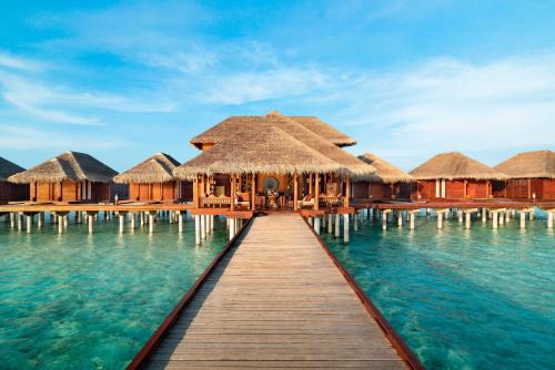a dock in the water with overwater bungalows at Anantara Dhigu Maldives Resort in South Male Atoll