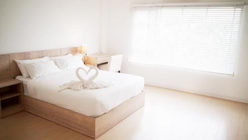 a bedroom with a bed with a heart decoration on it at The White Garden Premier Saraburi in Ban Dao Ruang